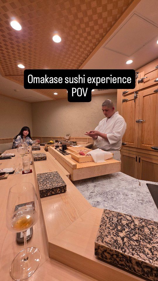 Blick von den Plätzen einer Omakase-Sushi-Theke auf den arbeitenden Chef