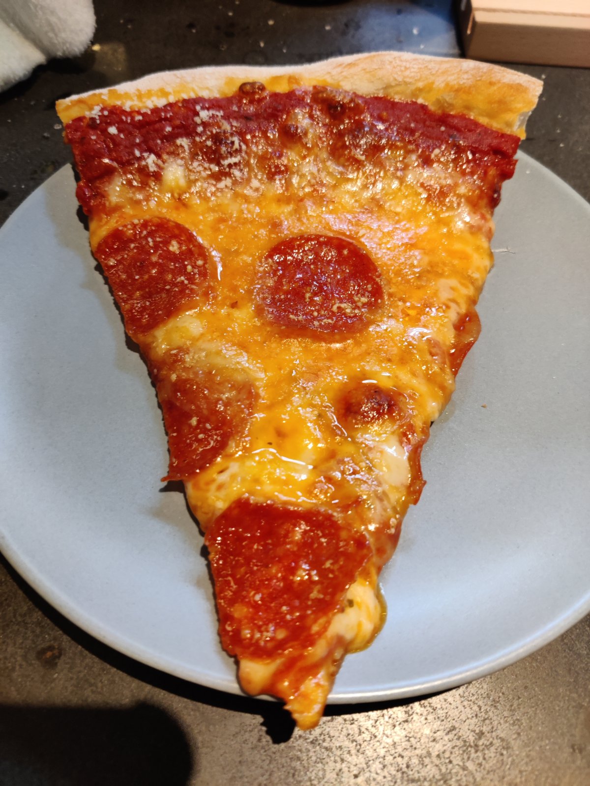 A large slice of pepperoni pizza on a plate