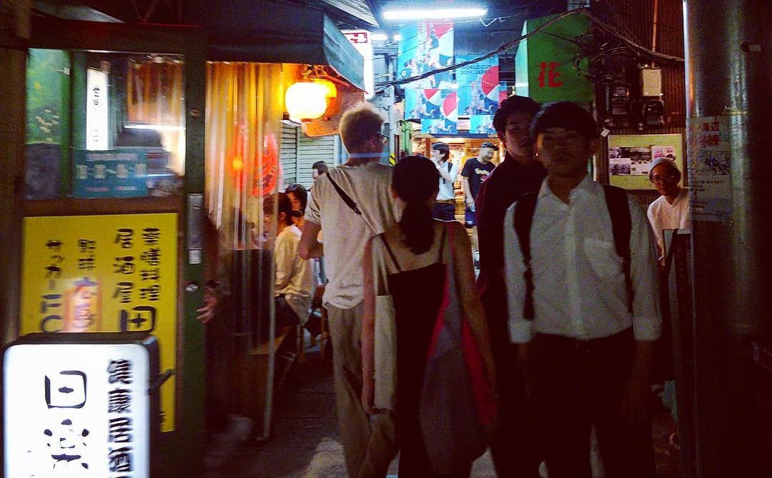 People strolling a lantern-lit yokocho drinking alley at night