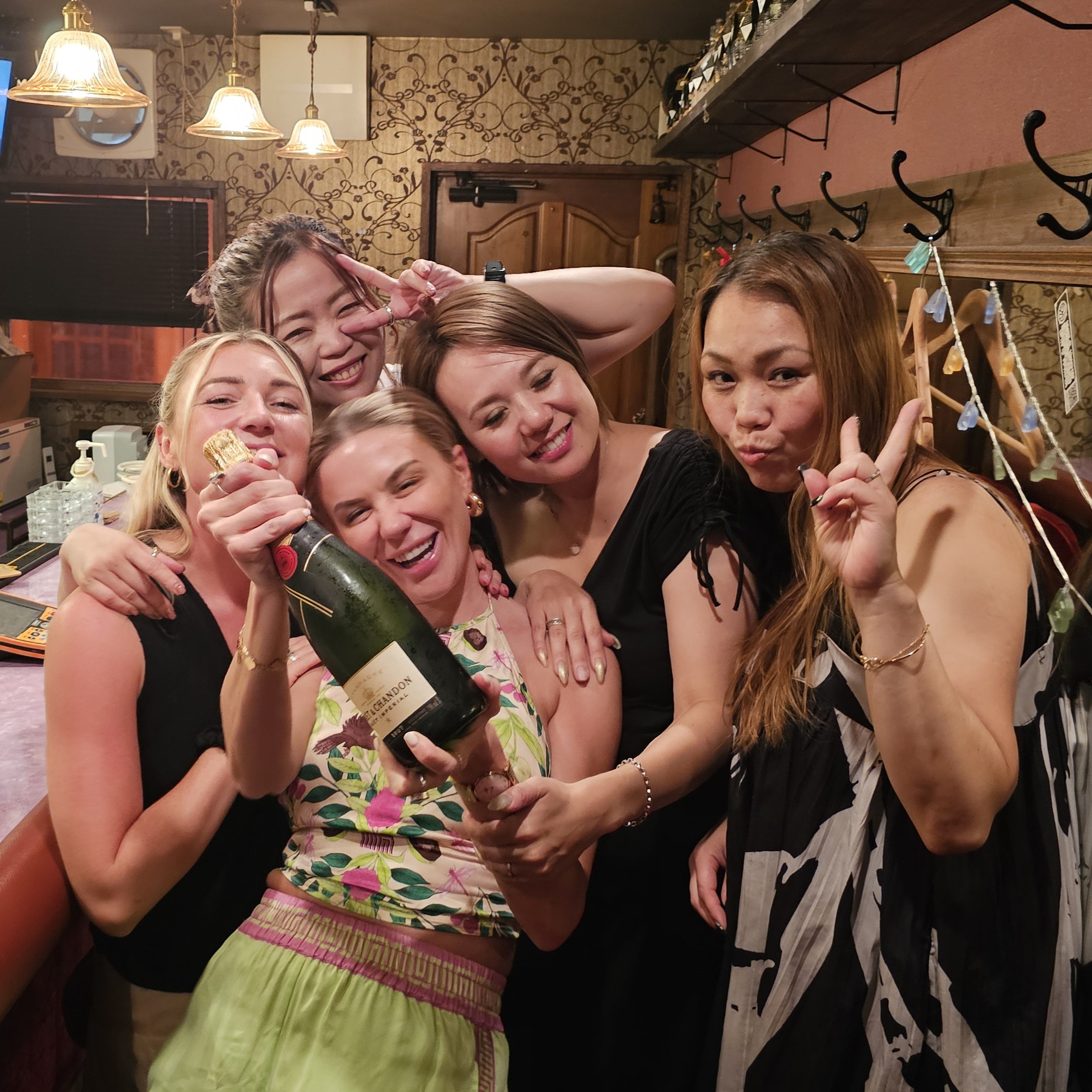 Friends celebrating with champagne inside a Tokyo bar