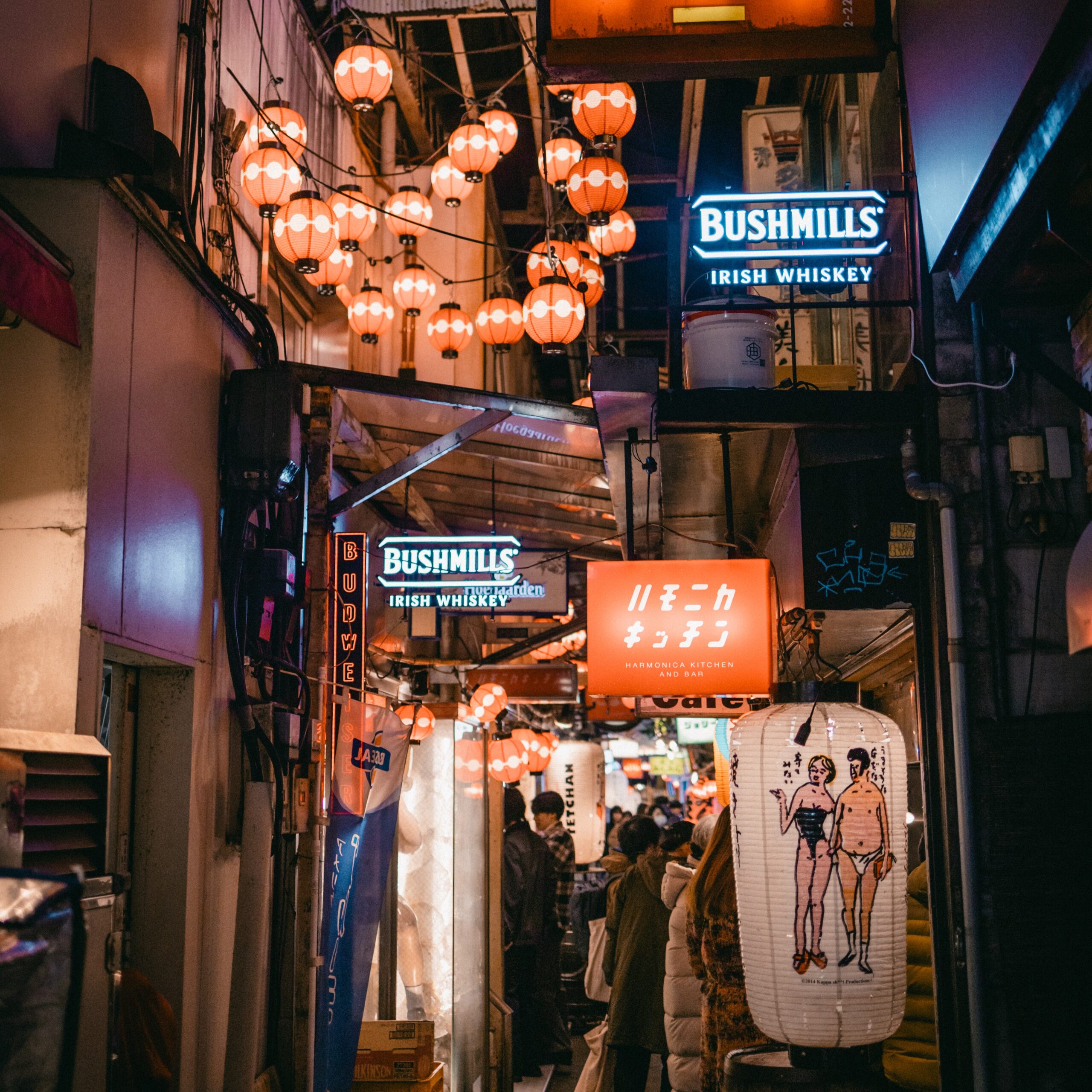Crowds walking a lantern-lit Tokyo alley packed with bars
