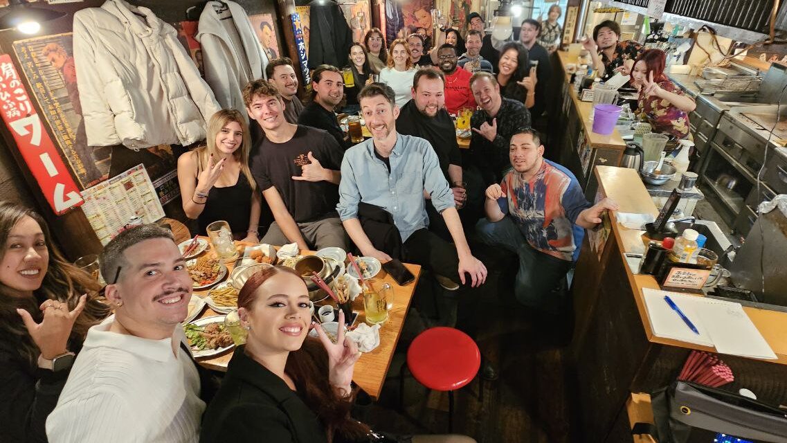 Large group of friends dining together at a Tokyo izakaya